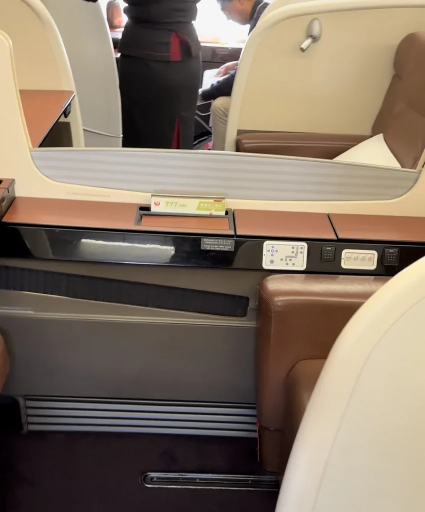 The middle seats in Japan Airlines first class have a retractable partition that you can lower or raise