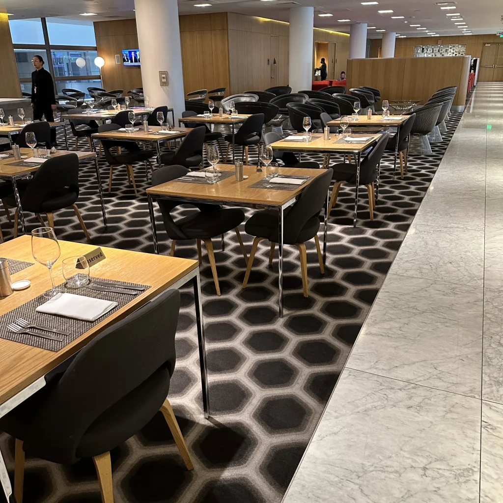 More dining area seating with tables for 2 people at Qantas First Class Lounge LAX