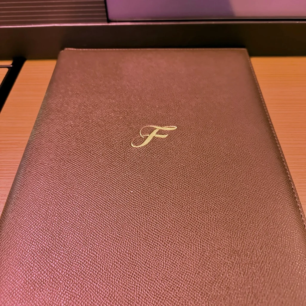 Japan Airlines First Class passengers receive a folder containing the food and beverage menus and customs forms