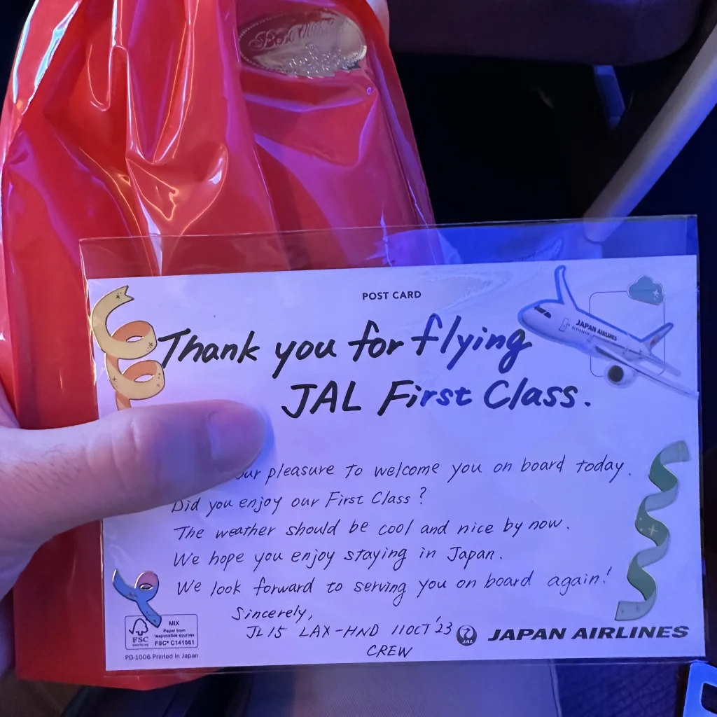 At the end of the Japan Airlines first class flight I received a handwritten postcard and a souvenir bag from the flight attendant 
