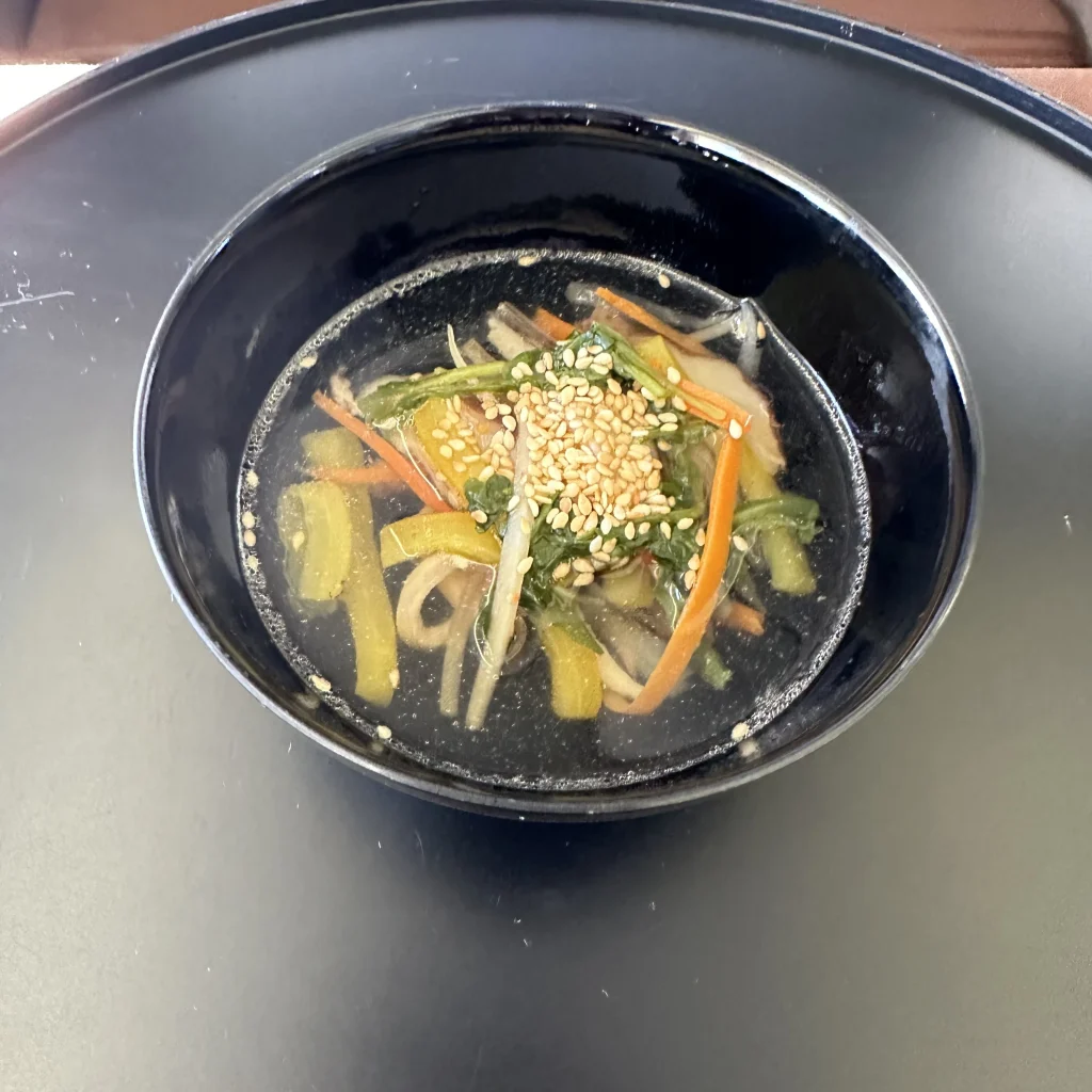 Japan Airlines first class passengers receive a course featuring Japanese clear soup with vegetables