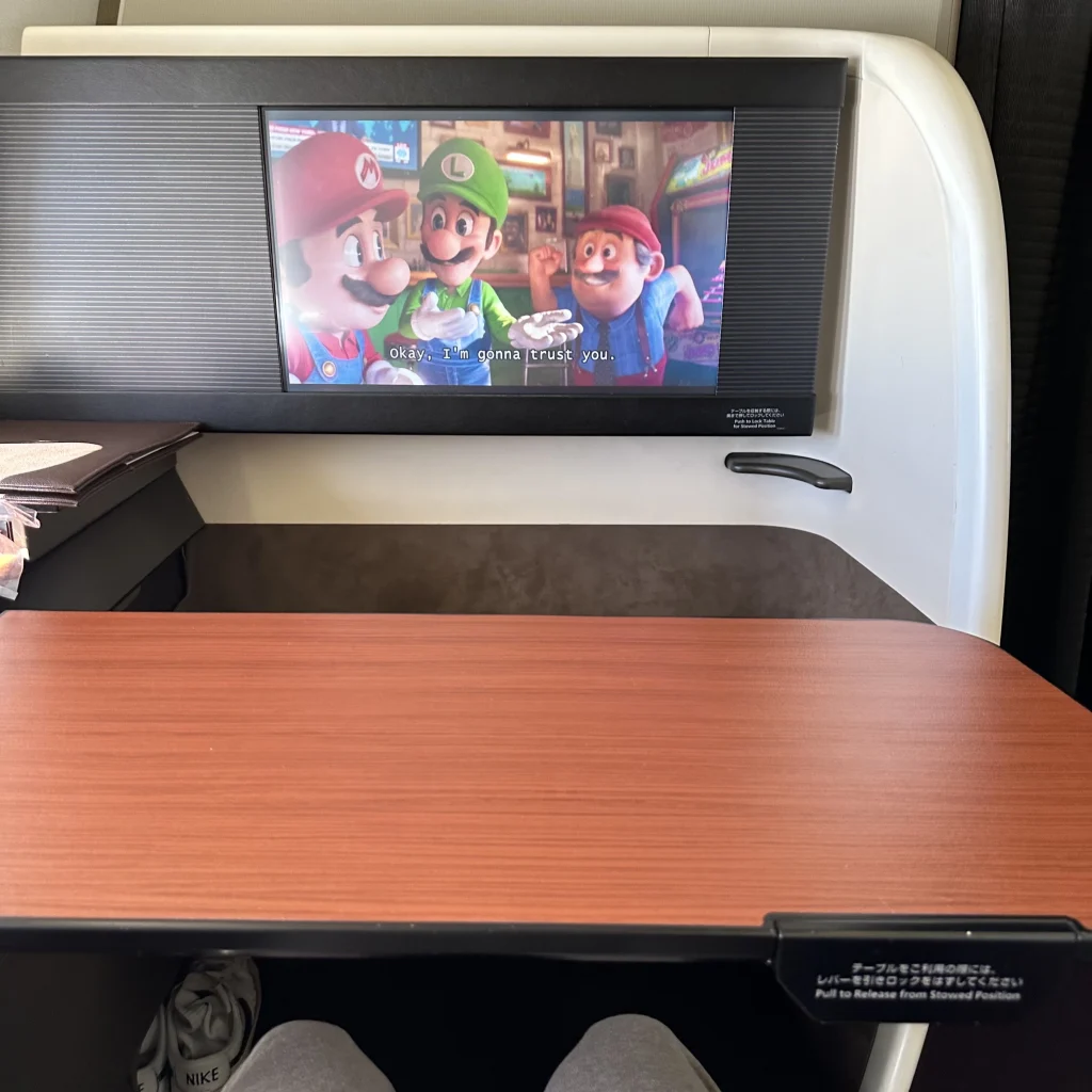 Japan Airlines first class has a large TV and a moveable dining table