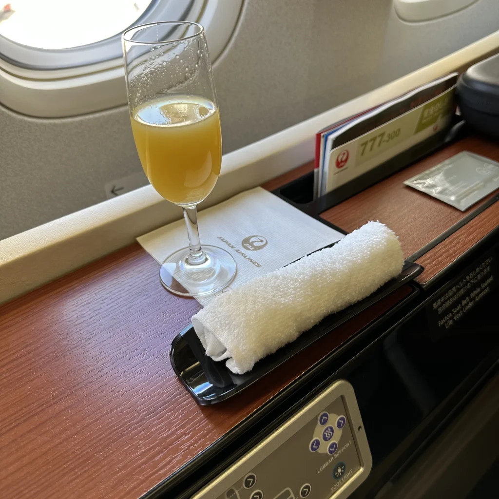 Japan Airlines first class passengers get their choice of a pre departure drink and a hot towel