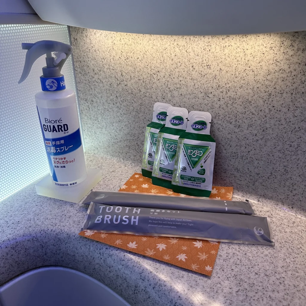 Japan Airlines business class bathrooms have toothbrushes, mouthwash, and other small amenities