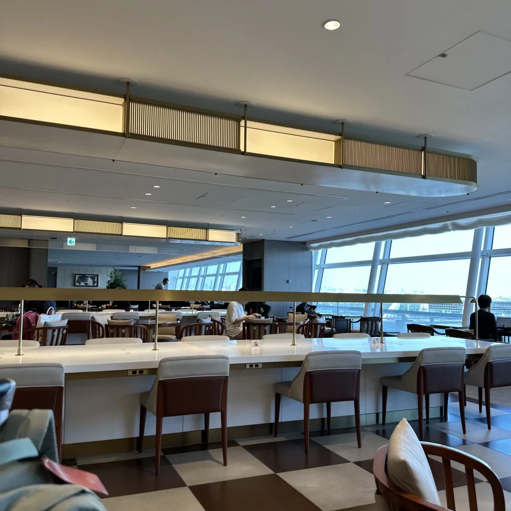 There are long dining tables in the Japan Airlines First Class Lounge