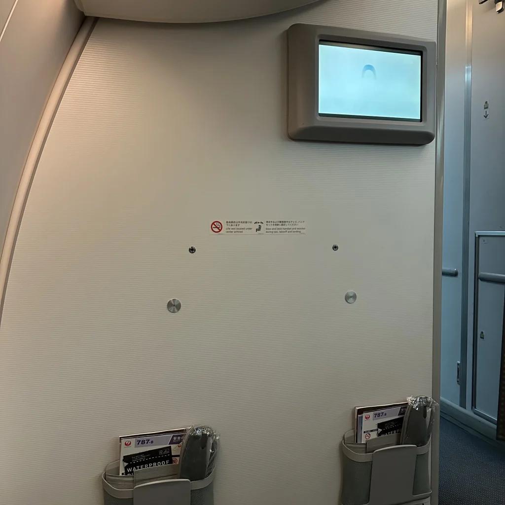 At the front of the cabin of Japan Airlines business class on the 787-8 is a small TV displaying information and a document holder