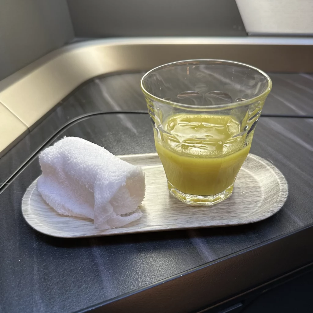 Starlux business class from Los Angeles to Taipei has a honey cucumber drink and hot towel given out pre departure