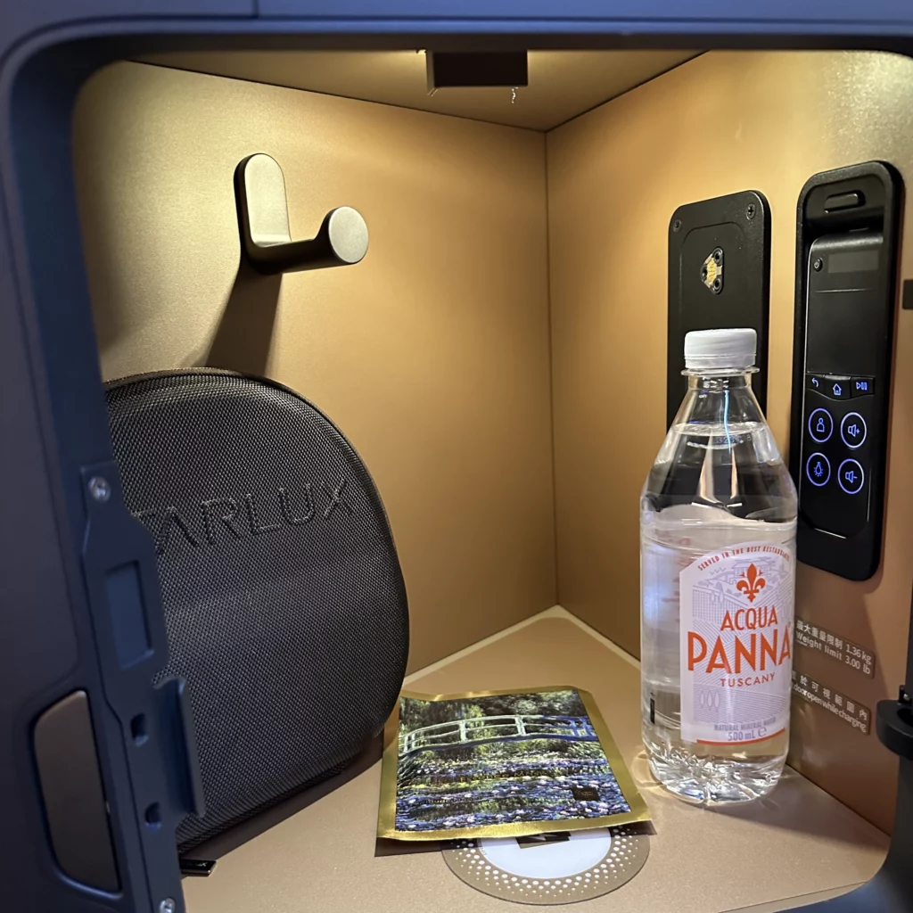 Starlux business class from Los Angeles to Taipei offers a storage compartment next to the headrest that stores the TV remote and heaphones