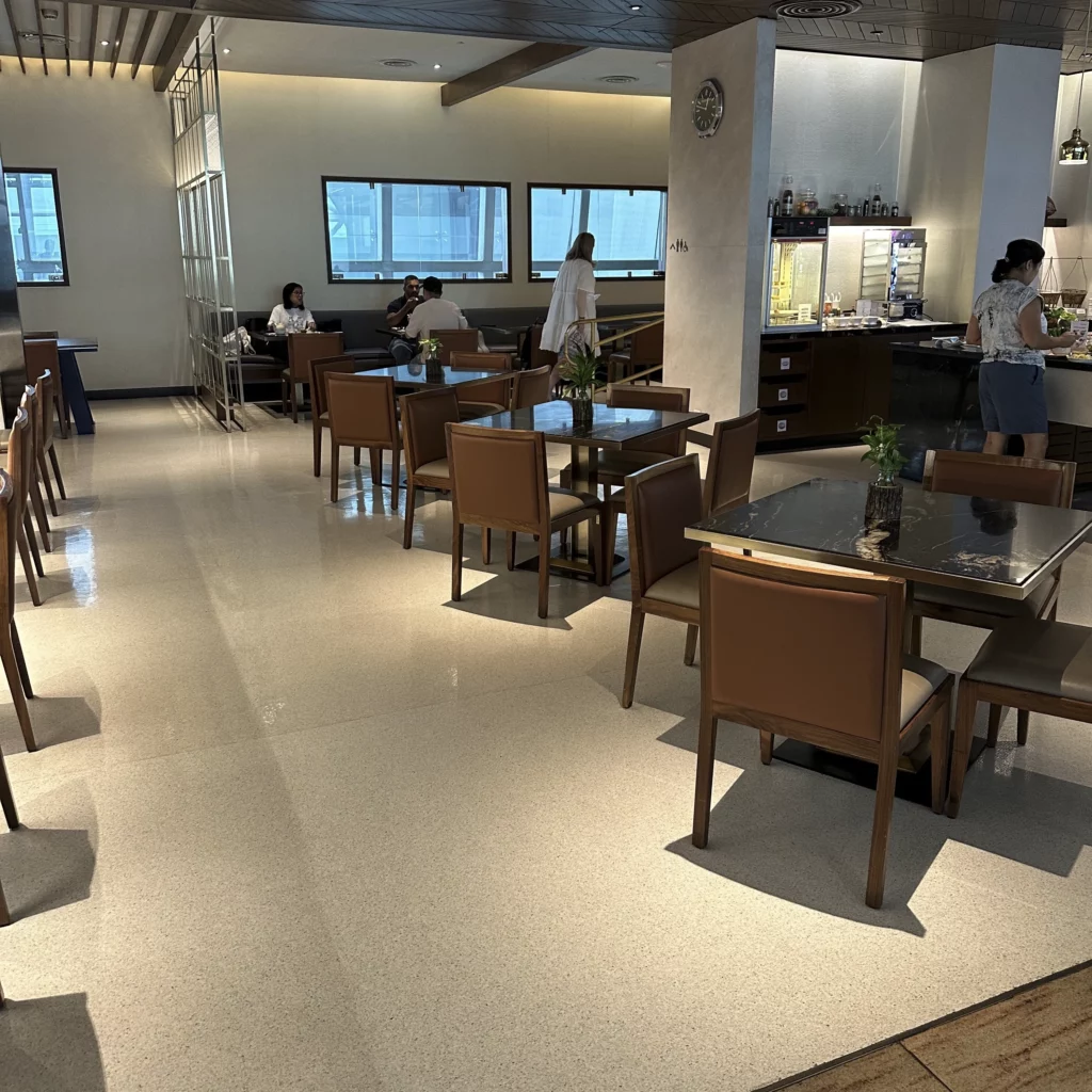 The Singapore Airlines SilverKris Lounge in Bangkok Suvarnabhumi Airport has a dining area with a few tables and bench