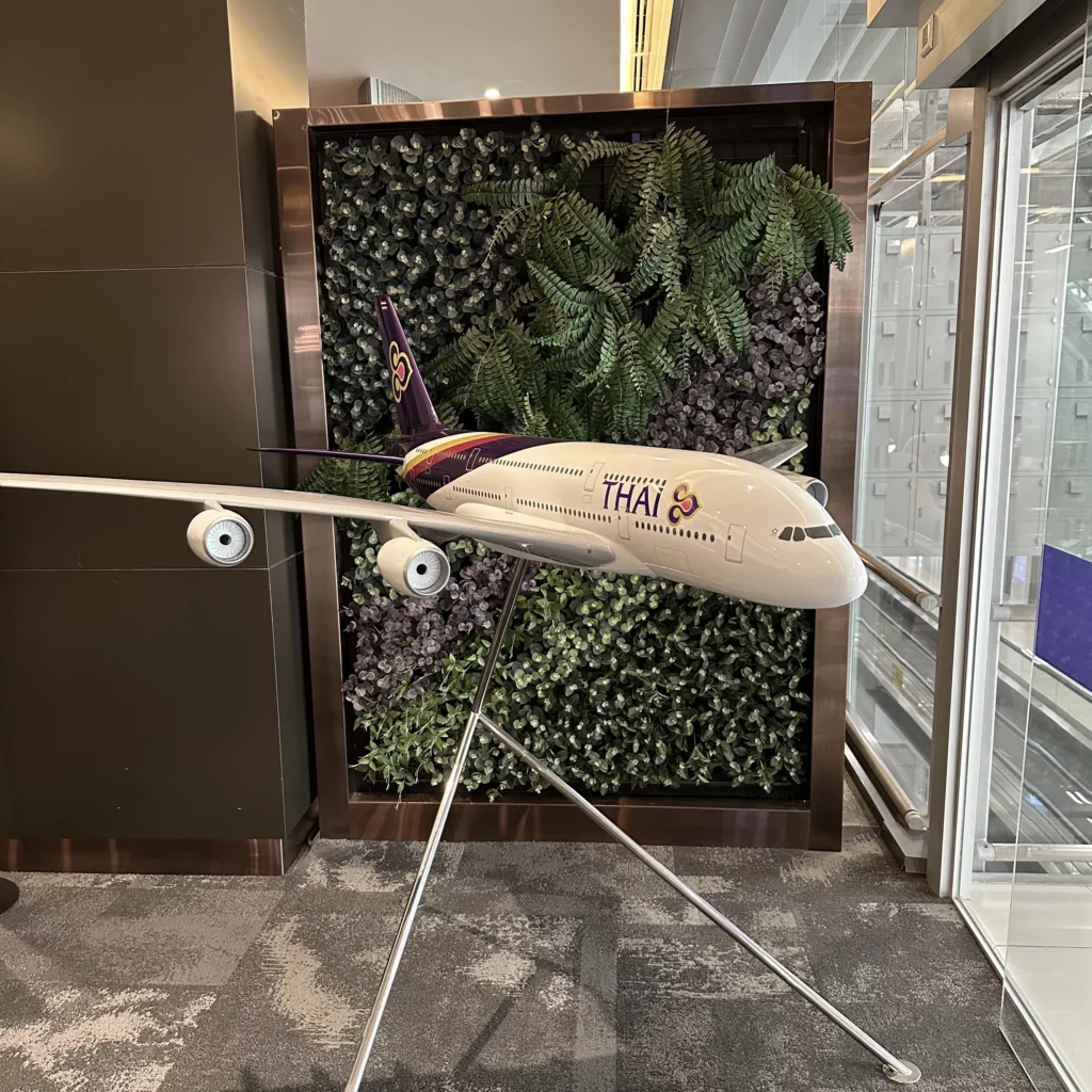 The Thai Airways Royal Orchid Prestige Business Class Lounge in Bangkok Suvarnabhumi Airport has a model A380-800 plane near the lounge entrance